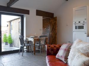 a living room with a couch and a table with chairs at Sunset Barn - Uk12855 in Normanby