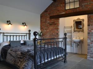 a bedroom with a black bed and a sink at Sunset Barn - Uk12855 in Normanby