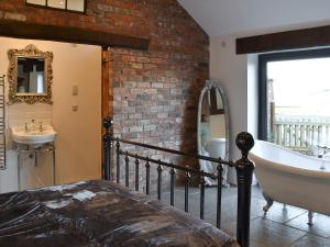 a bathroom with a tub and a sink and a claw foot bath tub at Sunset Barn - Uk12855 in Normanby