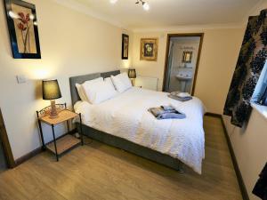 a bedroom with a bed and a table with a lamp at Moorings House in Fritton Norfolk