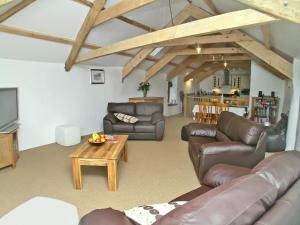 a living room with leather couches and a table at Proper Job in Tresmeer