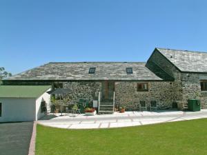 an old stone house with a patio and lawn at Proper Job in Tresmeer