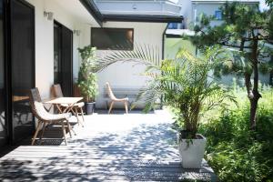 a patio with a table and chairs and plants at AMIGO HOUSE in Zushi
