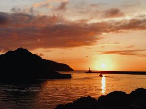 um barco no oceano ao pôr do sol em Book & Guesthouse Hitotomaru em Toyooka