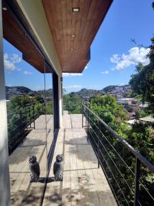 dos gatos sentados en el balcón de una casa en Casa Recanto da Neblina, en Petrópolis