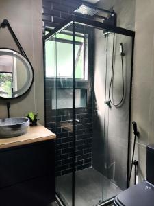 a shower with a glass door in a bathroom at Casa Recanto da Neblina in Petrópolis +32 photos