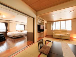 ein Schlafzimmer mit einem Bett und ein Wohnzimmer in der Unterkunft Hotel Tsubakino in Yamanouchi