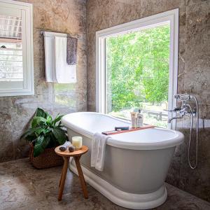 a bath tub in a bathroom with a window at Country Mile Escape in Canungra