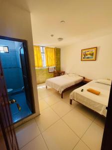 um quarto de hotel com duas camas e um chuveiro em Amazon Green Hotel em Iquitos