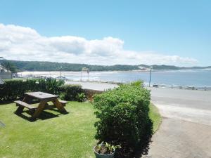 uma mesa de piquenique sentada na relva perto da praia em 5 Bayview Gonubie Seafront em Gonubie