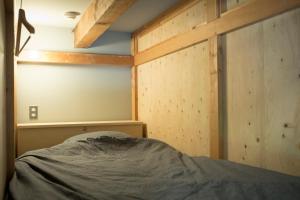 a bed in a room with wooden walls at AMIGO HOUSE in Zushi