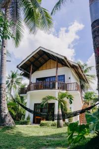 a large white house with palm trees in front of it at Palmera Palma Top Floor in Moalboal