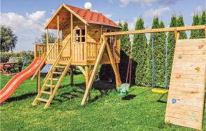 a wooden play house with a slide and swings at Beautiful Home In Mscice With Kitchen in Mścice