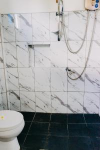 a white bathroom with a toilet and a shower at Palmera Palma Top Floor in Moalboal