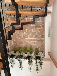 een kamer met een bakstenen muur en een trap met planten bij Knez apartments and rooms in Kaštela