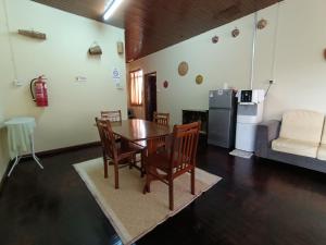 a dining room with a table and chairs and a couch at Mountain View Guest House KB in Kota Belud