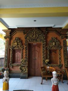 a room with a wall with two doors and a chair at Dharma homestay in Padangbai