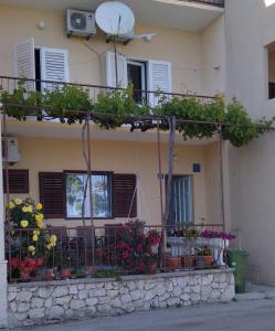 um edifício com vasos de plantas numa varanda em Apartment Marjana em Podgora