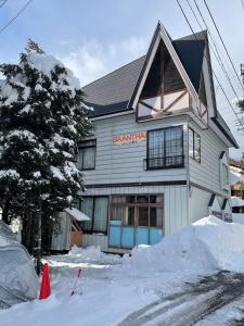 ein Gebäude mit Schnee davor in der Unterkunft 貸別荘バーンタイ戸狩 in Togari