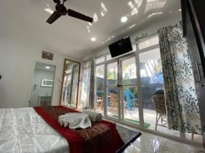 a bedroom with a large bed and a large window at Sand and Wood premium cottage palolem beach in Canacona