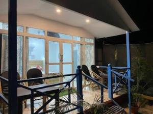 a living room with chairs and a large window at Sand and Wood premium cottage palolem beach in Canacona