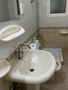a bathroom with a white sink and a tub at Welcom Tourist Hostel in Dubai