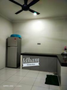 a kitchen with a refrigerator and a ceiling fan at Idham homestay in Ipoh