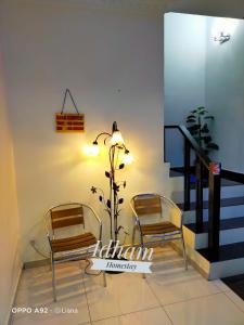 two chairs and a plant in a room at Idham homestay in Ipoh