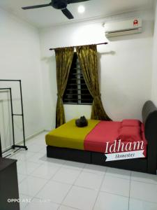 een slaapkamer met een kleurrijk bed in een kamer bij Idham homestay in Ipoh