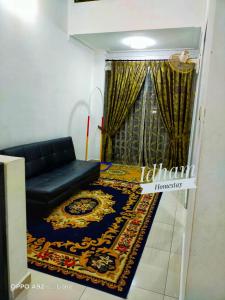 a living room with a couch and a rug at Idham homestay in Ipoh