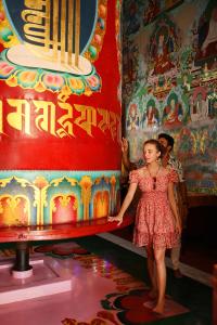 Una mujer con un vestido parada frente a una máquina en Sambodhi Retreat, en Bodh Gaya