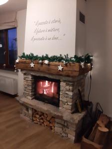 una chimenea de piedra con adornos navideños encima en Affittacamere La Lea, en Roccaforte Mondovì