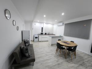 a living room with a table and a couch and a kitchen at Luz de Luna in Plottier