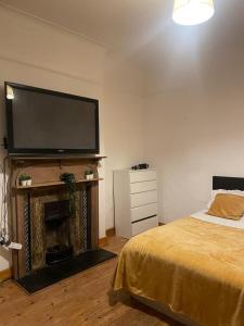 a bedroom with a bed and a flat screen tv at Balham, South London Spacious Guest House 1 in London