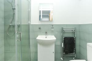 ein weißes Badezimmer mit Waschbecken und Dusche in der Unterkunft Atlas Place Broadstairs 4 bed family accommodation in Kent + 9 Fotos