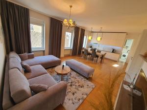 ein Wohnzimmer mit einem Sofa und einem Esszimmer in der Unterkunft Sarajevo City Soul Apartment in Sarajevo