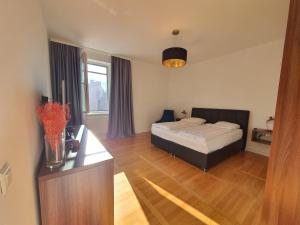 a bedroom with a bed and a desk and a window at Sarajevo City Soul Apartment in Sarajevo