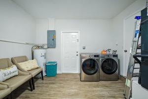 a laundry room with a washing machine and a couch at Ixora6 Heated pool mins to beach airport USSSA in Melbourne