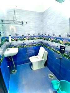 a blue bathroom with a toilet and a sink at Hotel Aradhana palace in Rishīkesh