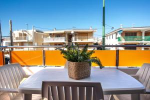 a table with two chairs and a potted plant on a balcony at Apartamento a 50 metros de la playa, Luminoso y acogedor in Oliva