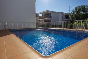 a swimming pool with blue water in a building at Apartamento a 50 metros de la playa, Luminoso y acogedor in Oliva