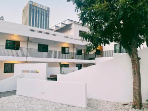 Un edificio blanco con un árbol delante. en Hidden Garden Youth Hostel -Oriental Pearl &Lujiazui -Garden Social Area -Bar -Café -Free Laundry Luggage Storage -24H Front Desk -English Service, en Shanghái