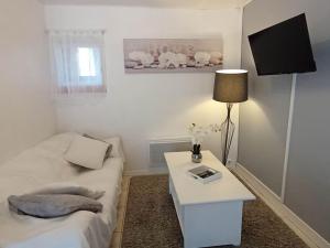 Habitación blanca con cama y mesa con lámpara en Gîte Périgord Rocamadour Sarlat Gourdon naturiste de juin à sept, en Salviac