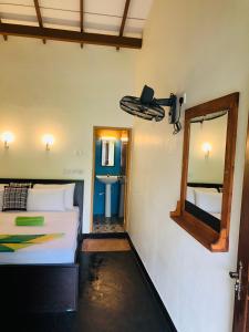 a bedroom with two beds and a mirror and a sink at Sigiri Liya Rest in Sigiriya