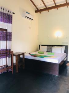 a bedroom with a bed and a table in it at Sigiri Liya Rest in Sigiriya