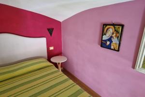 ラヴェッロにあるCasa Angelicaのピンクの壁、ベッド1台付きのベッドルーム1室