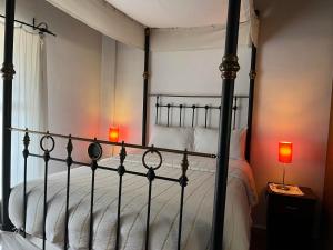 a bedroom with a black canopy bed with two lamps at Ambelikos Traditional Agrohotel in Potamitissa