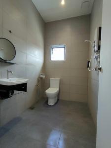 bagno con servizi igienici, lavandino e finestra di Muji Designer Suite a Jeram