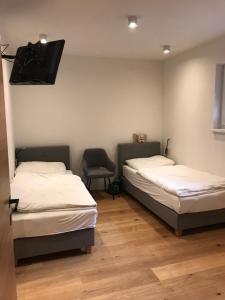 a room with two beds and a tv on the wall at Ferienwohnung Talbach in Schladming