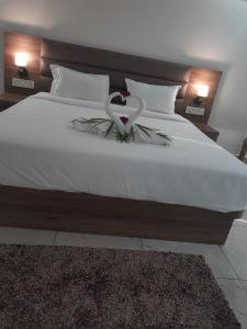 a bedroom with a bed with a flower on it at Flamingo Club and Resort Una 3 Km Away from Diu Check Post in Diu